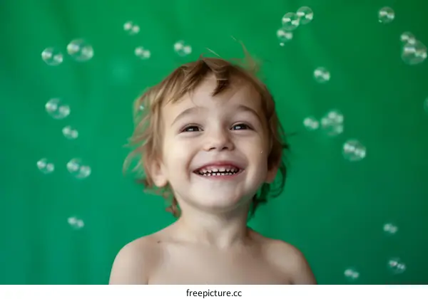 Toddler boy laughing with bubbles around him