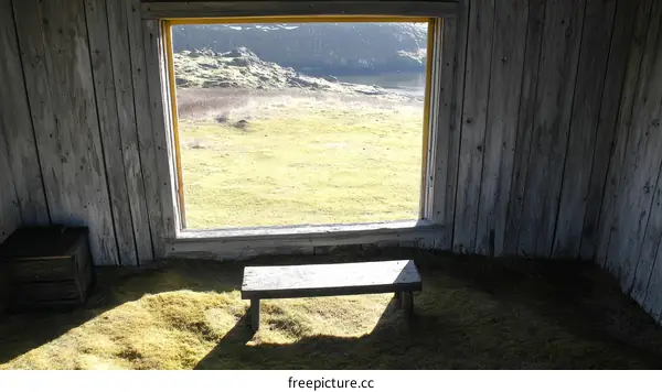 Wooden Cabin Interior with a View of Grassland