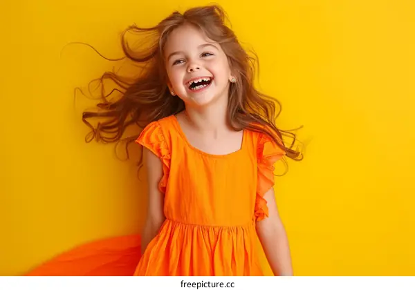 Portrait of a happy little girl in an orange dress