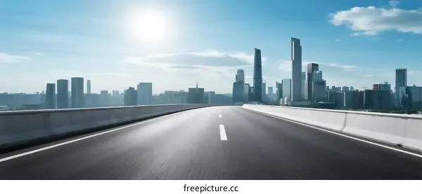 Smooth highway leading to modern city skyline under bright sun