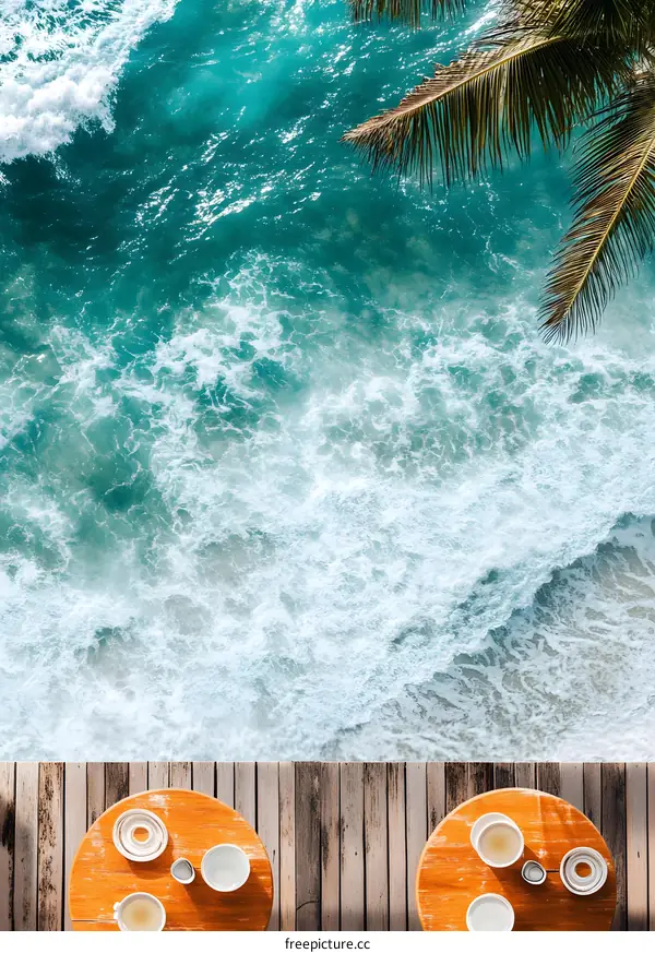 Overhead View of Two Tables on a Wooden Deck with Ocean Waves in the Background