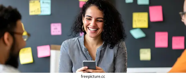 Smiling Woman Looking At Phone in Office Setting