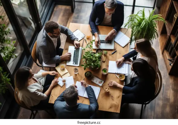 A group of people are sitting around a table having a meeting