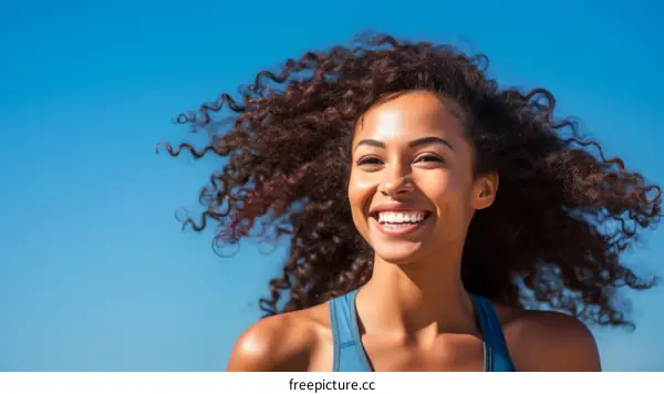 A young woman with curly hair smiling