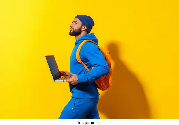 Man with Laptop and Backpack against Yellow Background