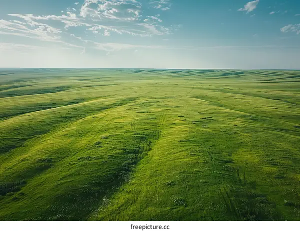 Green rolling hills under blue sky with clouds