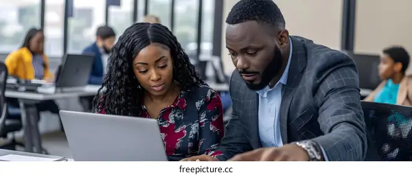 African American Businessman and Woman Working on Laptop in Office