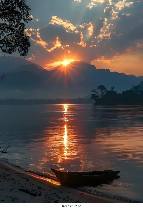 sunset over river with boat and mountains
