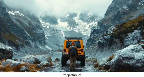 Young caucasian man with backpack standing in front of snowy mountains