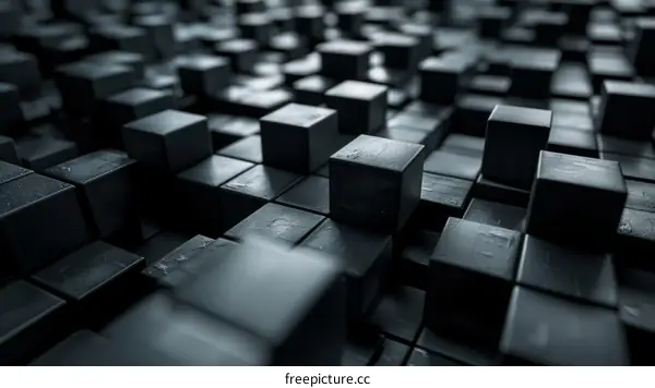 Abstract 3D rendering of a surface of black cubes with beveled edges lit by a spotlight