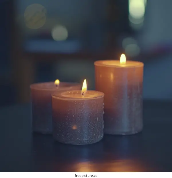 Three brown candles burning with a blurred background