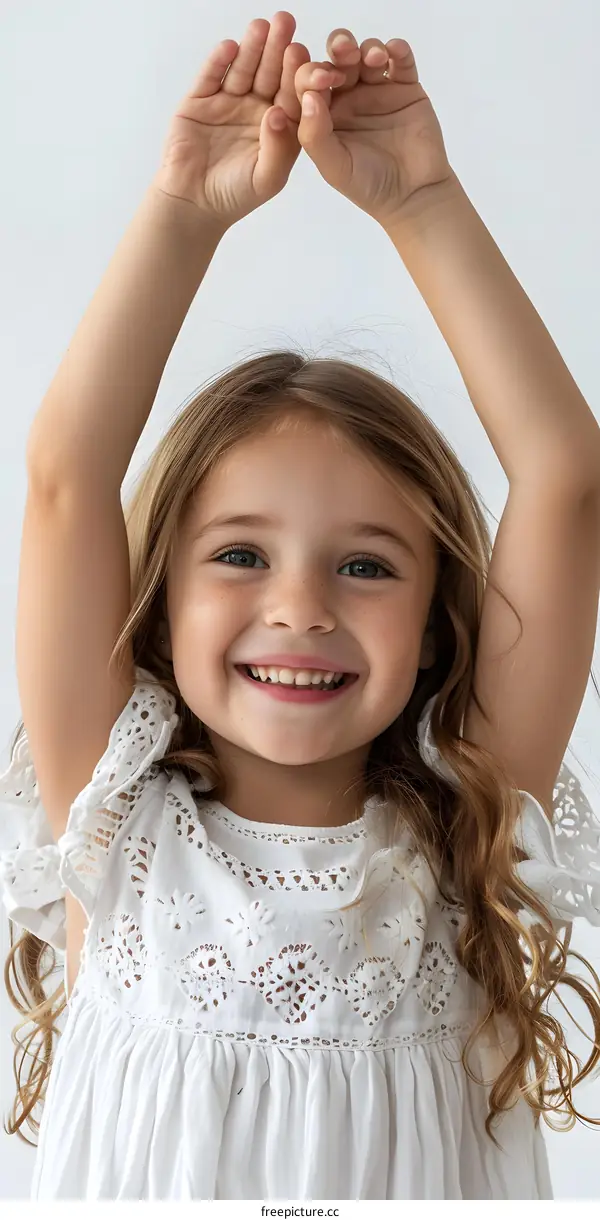 Portrait of a smiling girl with freckles raising her arms