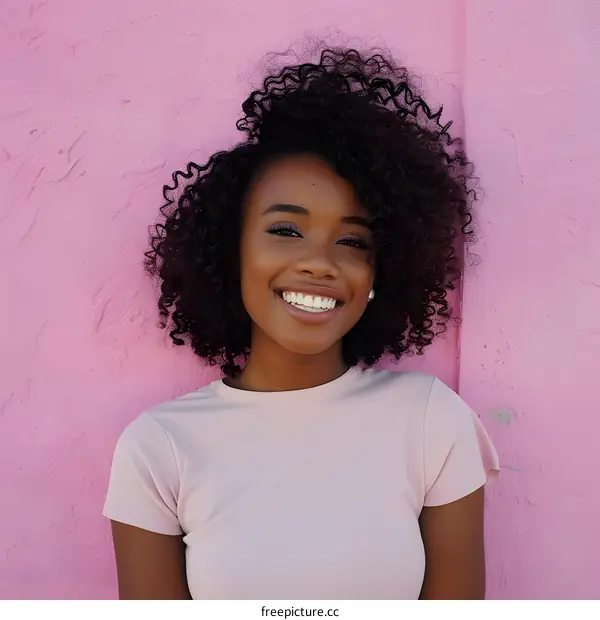 Smiling African American Woman in Pink T Shirt Against Pink Wall