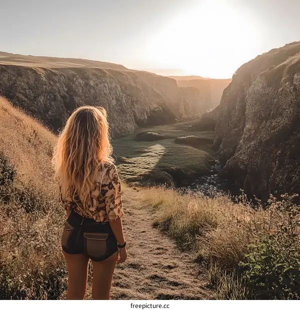 Woman Standing on a Path Looking Out at a Canyon