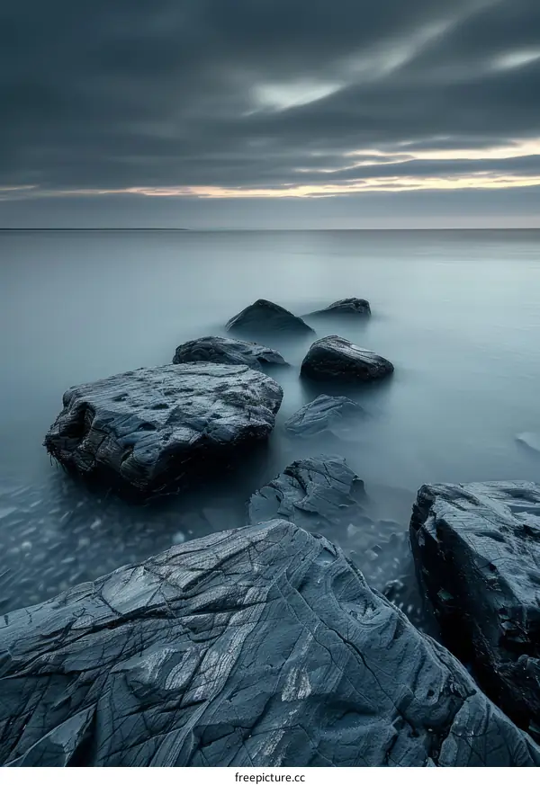 Large dark rocks in a calm sea at sunset