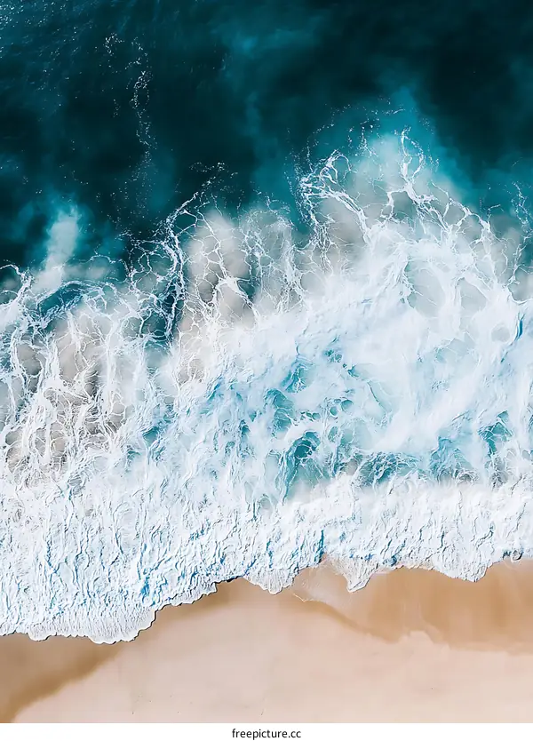 Aerial View of Ocean Waves Crashing on Sandy Beach