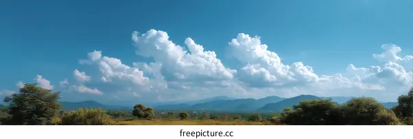 Vast Sky with Fluffy Clouds and Lush Landscape