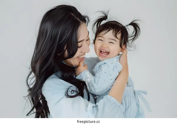 Mother and Daughter Smiling Together in Blue Outfits