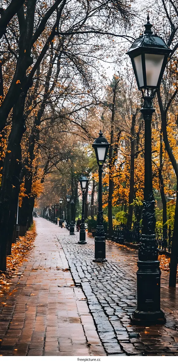 Autumn Walkway with Streetlights and Cobblestone Path