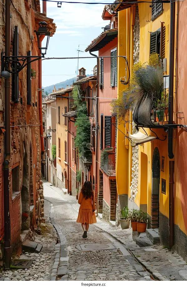 Woman walking down a narrow cobblestone street in Italy