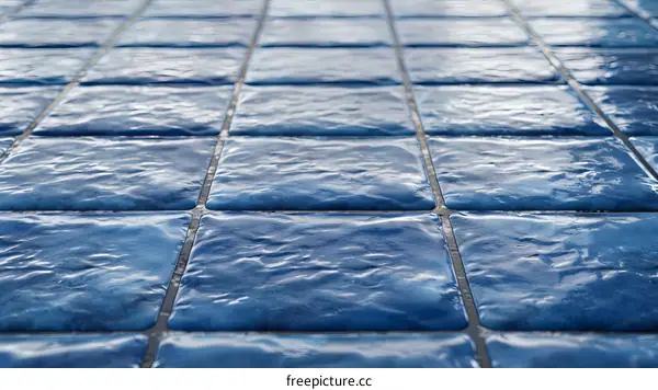 Blue ceramic tiles with water caustics reflecting on the surface