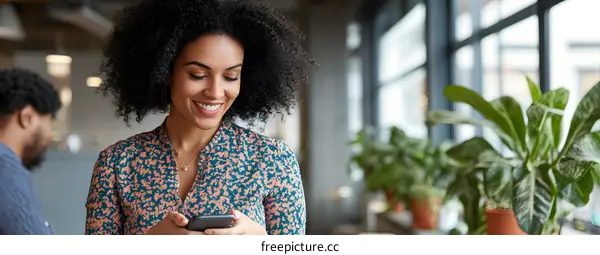 Smiling Woman Checking Her Phone in Office