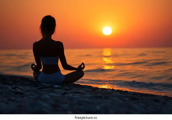 Silhouette of Woman Meditating at Sunset on Beach