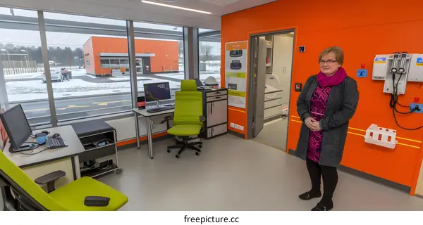 Modern Medical Office Interior with Woman Doctor in Front of Orange Wall