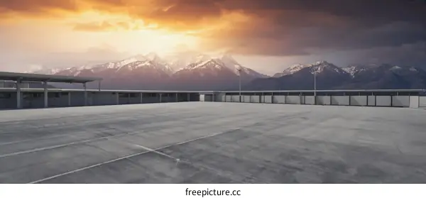 Empty Rooftop Parking Lot with Snowy Mountains