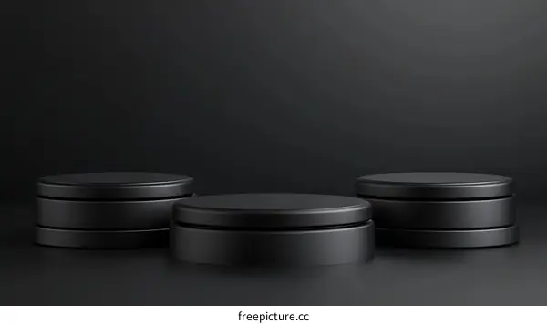 Three Black Cylindrical Display Podiums on Dark Background