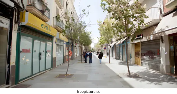 Empty Street in Spain with Closed Shops and Few People Walking