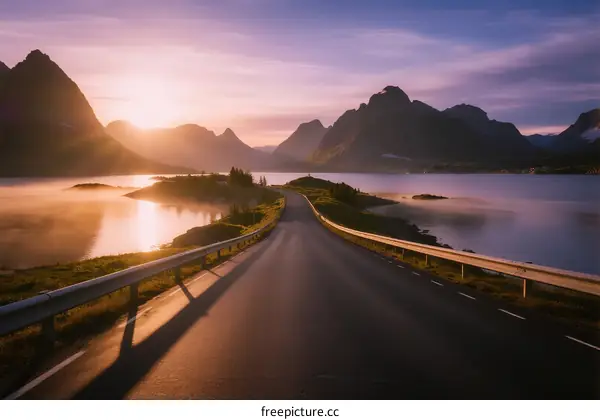 Sunlit Road Through Scenic Mountain and Lake Landscape