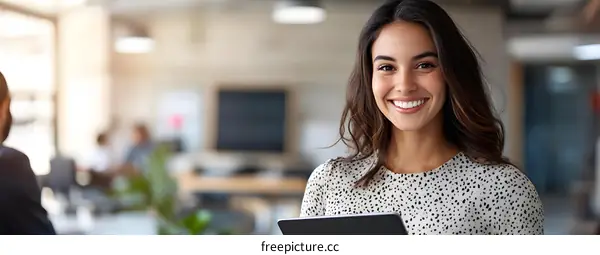 Smiling Woman Holding Tablet in Office