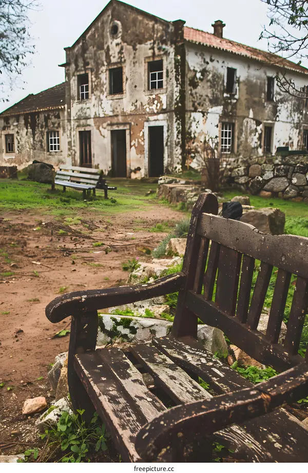 Old Wooden Bench in Front of an Abandoned House