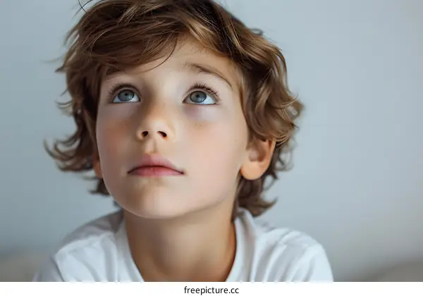 Portrait of a boy with freckles and blue eyes looking up