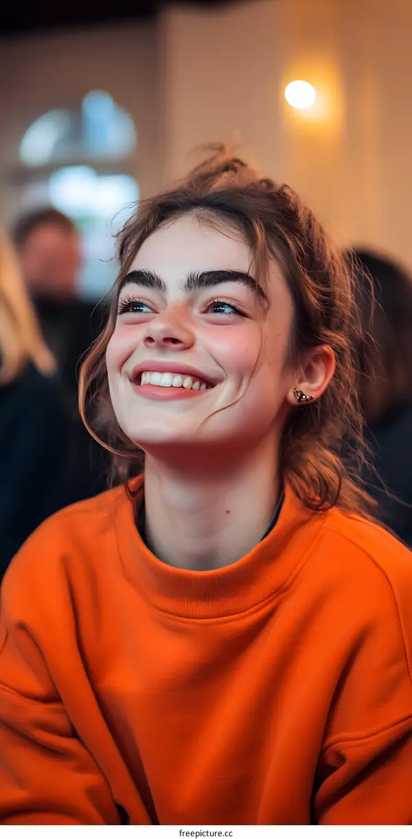 Smiling Young Woman in an Orange Sweatshirt