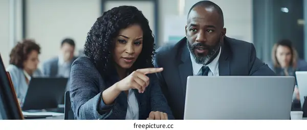 Business Professionals Discussing Project on Laptop