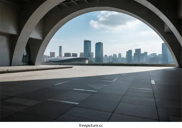 Modern arch structure with city skyline in the background