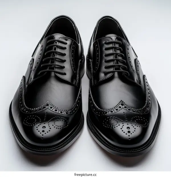 A pair of black leather shoes with brogue details