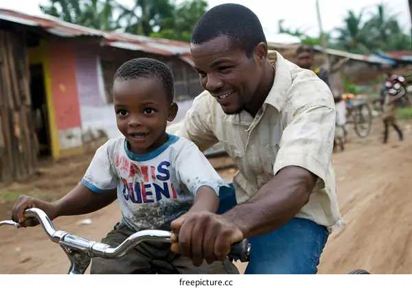 African Father Teaching Son to Ride a Bike