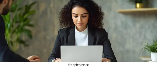 Focused Businesswoman Working on Laptop at Office Desk