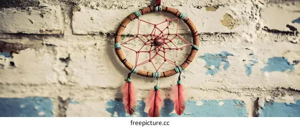Dreamcatcher with Feathers Hanging on a Brick Wall