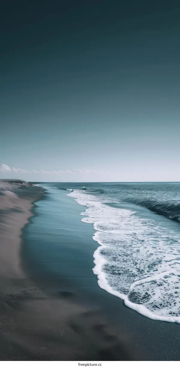 Beach with dark sand and dark blue water