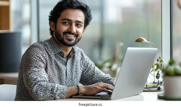 Smiling Young Man Working on Laptop