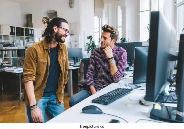 Two Caucasian Colleagues Discussing in Modern Office