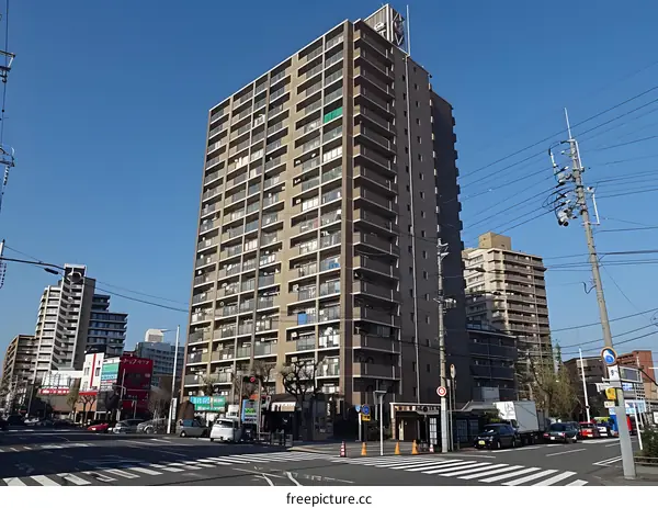 A residential building stands at a crossroads in a city