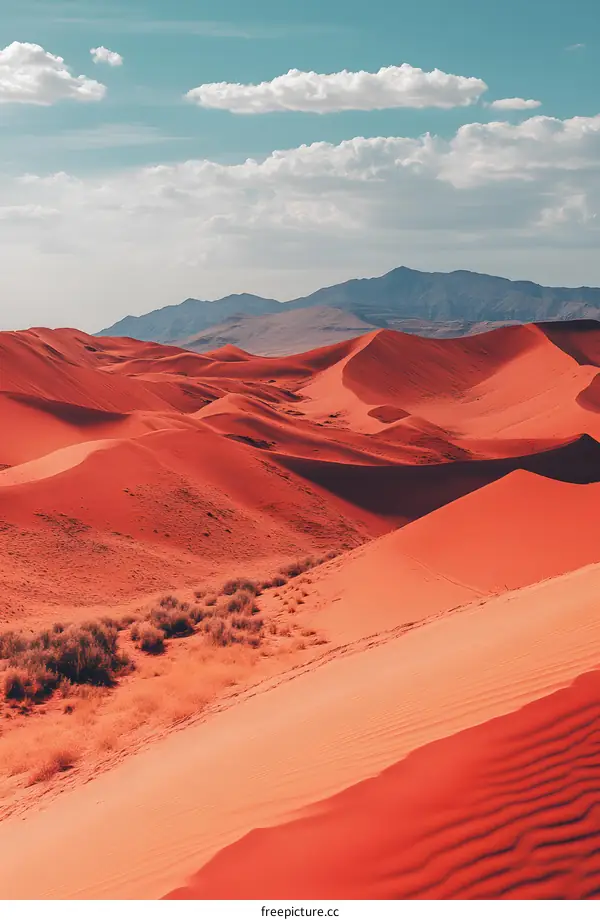 Red Sand Dunes in the Desert with Blue Sky and Clouds