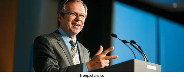 Businessman Speaking at a Conference with Microphones
