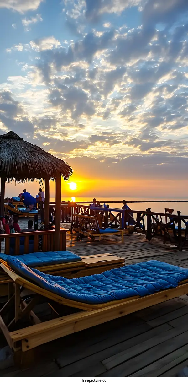 Sunset View from Wooden Deck with Loungers and People