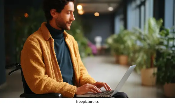 Man in Wheelchair Working on Laptop in Modern Office